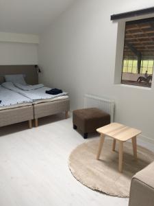 een slaapkamer met 2 bedden en een salontafel bij Flyingehus Gårdshotell in Flyinge