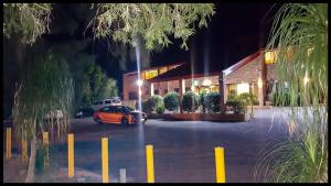 an orange car parked in a parking lot at night at Windsor Terrace Motel in Windsor