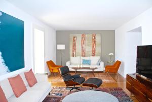 uma sala de estar com um sofá branco e cadeiras em Santa Catarina Luxury Apartment em Lisboa