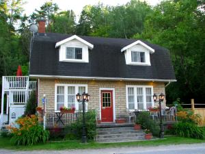 a small house with a red door at Auberge De Mon Petit Chum B&B in Wakefield