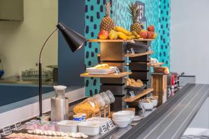 uma linha de buffet com frutas e outros alimentos em exposição em B&B HOTEL São José dos Campos em São José dos Campos