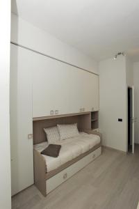 1 dormitorio con 1 cama con una gran pared blanca en Le Gemme 1, en Empoli