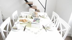 アルベンガにあるAntica Dimoraの白いダイニングテーブル(白い椅子付)、食器一皿