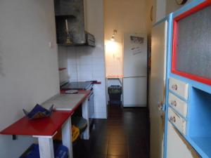 una pequeña cocina con encimera roja y nevera. en La casa nel borgo, en Arrone