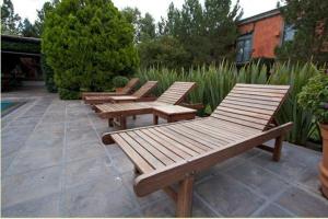 a row of wooden benches sitting on a patio at Hotel Gobernador in Durango