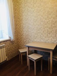 Kozel'skにあるApartment on Tsiolkovskogo 10の壁のある部屋(テーブル2台、ベンチ付)