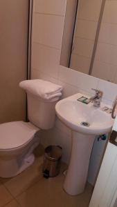 Un baño blanco con inodoro y lavabo. en Hotel Romano, en Concepción 28 fotos más