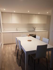 a kitchen with a white table and chairs at Lac et Montagne in Duingt