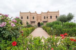budynek z ceglanym chodnikiem przed kwiatami w obiekcie Villas Fleurs Marrakech w Marakeszu
