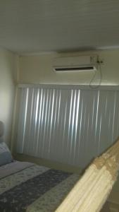 a bedroom with a bed and a air conditioner on a wall at Expedito acomodações in Manaus