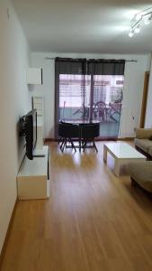 sala de estar con mesa, sofá y TV en Apartamento Mataro, en Mataró