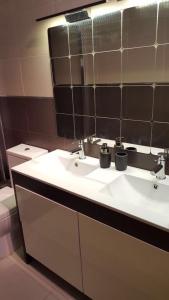 łazienka z 2 umywalkami i lustrem w obiekcie Apartamento Mataro w mieście Mataró