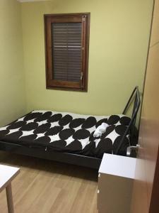 czarno-białe łóżko w pokoju z oknem w obiekcie Apartamento Mataro w mieście Mataró