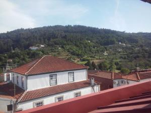 una casa blanca con techos rojos y una montaña en Penthouse - Low Cost, en Vouzela