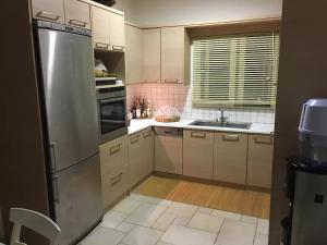 a kitchen with white cabinets and a stainless steel refrigerator at Villa Costa Hydra in Plépi
