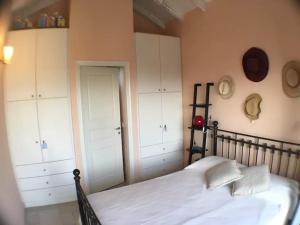 a bedroom with a black bed and white cabinets at Villa Costa Hydra in Plépi