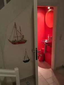 a bathroom with a red room with a boat on the wall at Villa Costa Hydra in Plépi +10 photos