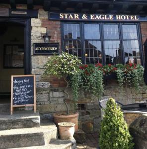 un hôtel d'étoiles et d'aigles avec un panneau devant lui dans l'établissement The Star And Eagle Hotel, à Goudhurst