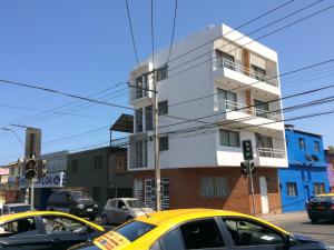 dos autos amarillos estacionados frente a un edificio en Hospedaje Amunátegui, en Iquique