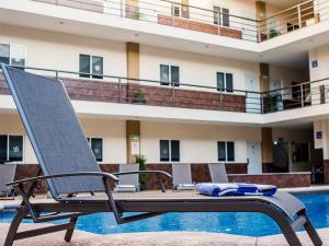 a lounge chair sitting next to a swimming pool at Gran Hotel Residencial Galerias in Ciudad Obregón