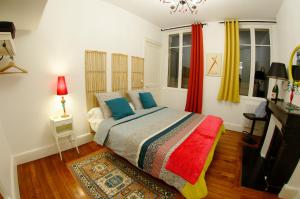1 dormitorio con 1 cama con una manta colorida en La Mignonette en Épernay