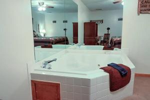 a bathroom with a sink and a large mirror at Bear Camp By The Night in Pigeon Forge