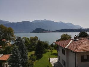 einen Blick auf einen See mit einem Haus und die Berge in der Unterkunft Cadenabbia Fantastico in Griante Cadenabbia