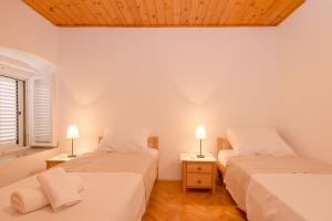 duas camas num quarto com duas lâmpadas nas mesas em Apartment Mediteran em Stari Grad