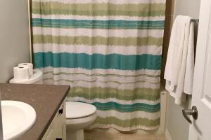 a bathroom with a toilet and a shower curtain at The Suite Vista in Waterloo