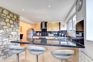 eine große Küche mit einer großen Theke mit Hockern in der Unterkunft Ger-y-llyn in Bonvilston + 42 Fotos