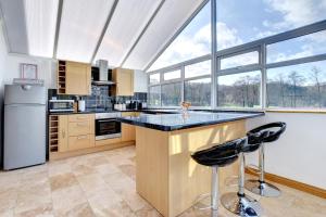 a kitchen with a large island with black counter tops at Uwch-y-llyn in Bonvilston