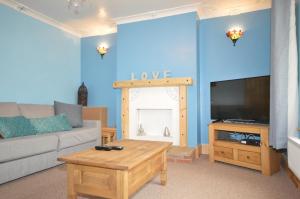 a living room with a couch and a tv at Whole House - Sleeps 5 - near town centre - off road parking in Hinckley