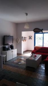 a living room with a red couch and a tv at Il Mare in Larnaca