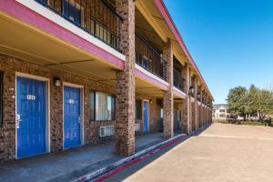 een rij blauwe deuren op een bakstenen gebouw bij Motel 6-Arlington, TX - UTA in Arlington