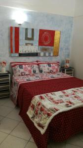 een slaapkamer met een bed met een rood dekbed bij Antoinette in Gaeta