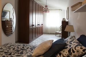 een slaapkamer met een bed, een spiegel en een deur bij Casa Michela in Vico del Gargano