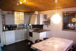 ノールハイムスンにあるHardanger Feriesenter Nesvikaのキッチン(白いキャビネット、テーブル、椅子付)