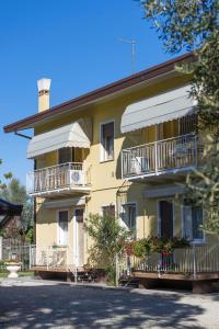 a yellow building with balconies and a street at Appartamenti & Bungalows Luca Angiolin in Cavallino-Treporti