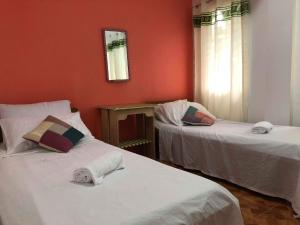 duas camas num quarto com paredes vermelhas em R&E Bed & Breakfast em Ivana