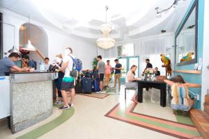 a group of people standing around a bar in a restaurant at South Beach Rooms and Hostel in Miami Beach