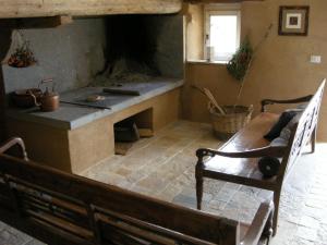 a room with a fireplace with a table and a bench at Agriturismo Pian Di Meta Vecchia in Castiglione dʼOrcia