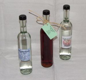 three glass bottles with labels sitting on a table at Ferien-am-Bauernhof-Wohnung-2 in Rangersdorf