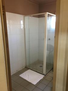 a bathroom with a shower stall and a toilet at Taylors Hotel in Mackay
