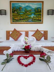1 dormitorio con 2 camas y un cuadro en la pared en Karma House en Ubud