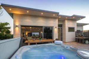a bath tub in front of a house at Lakefront Luxury by Amazing Accom in Queenstown