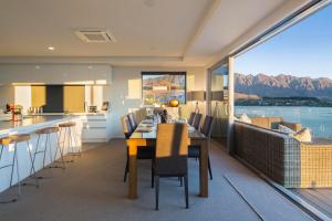 a kitchen and dining room with a table and a large window at Lakefront Luxury by Amazing Accom in Queenstown