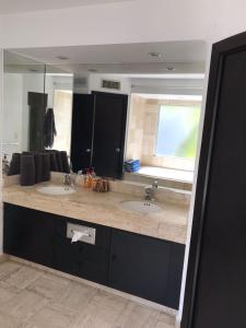 a bathroom with two sinks and a large mirror at Mayan Vidanta Playa Departamento 3 Recamaras varias albercas in Acapulco