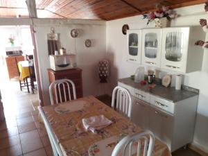 a kitchen with a table and a table and chairs at Casa da Dona Ilda in Pirenópolis