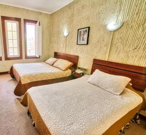 um quarto de hotel com duas camas e uma janela em Si Hotel em Santiago