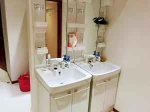 a bathroom with two sinks and a mirror at Guesthouse LuLuLu 無料朝食&夕食ｶﾚｰ 街まで電車8分 ﾛｰｿﾝ隣 in Kochi +13 photos